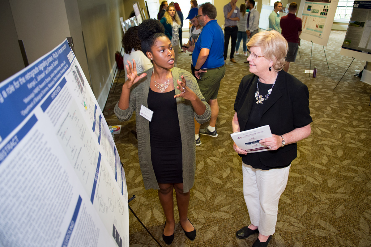 Kenya Johnson tells Provost Judy Bonner about her undergraduate research project.