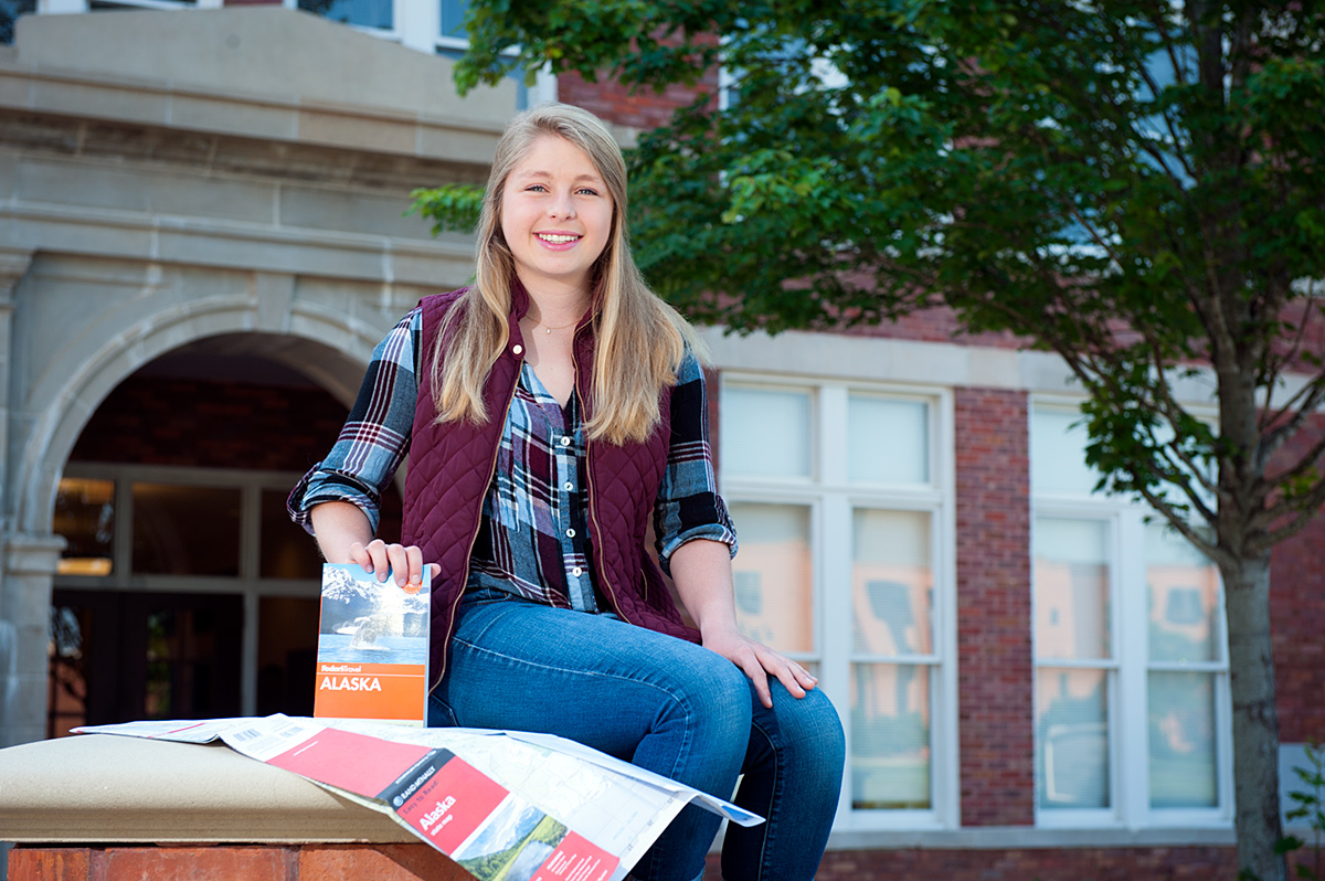 Emily Turner, pictured on the MSU campus with an Alaska travel guide.