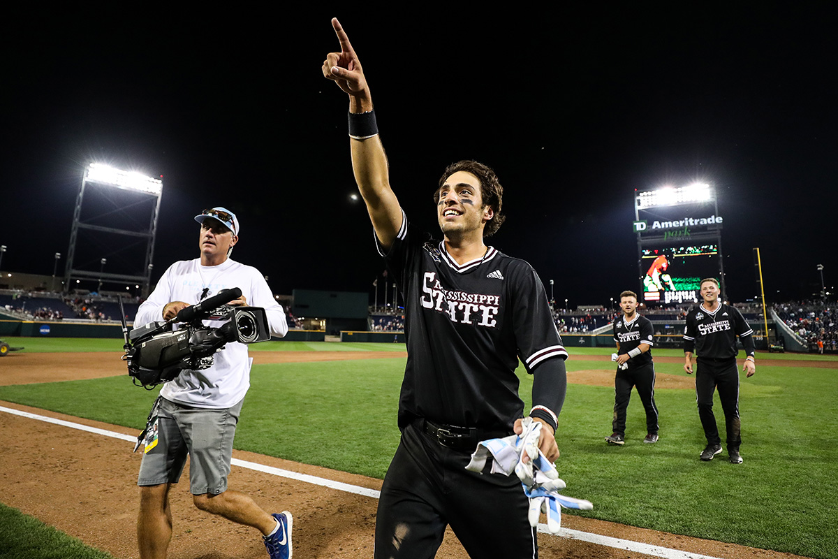 Baseball player in black in uniform pointing into the crowd on baseball field