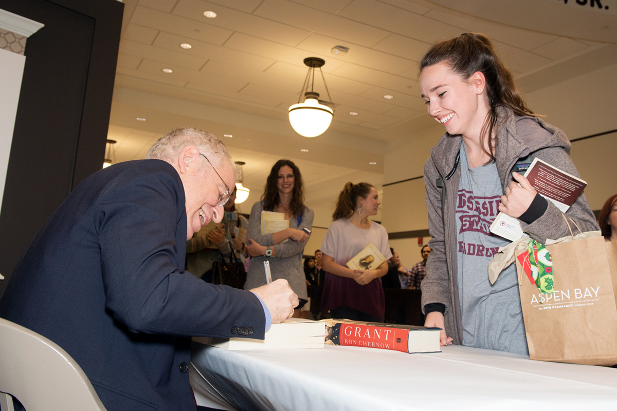 Author Ron Churnow sharing a laugh with student while signing his book.