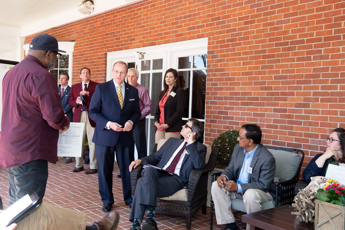 President Keenum welcoming faculty senate members on the back patio of his home prior to the session starting.