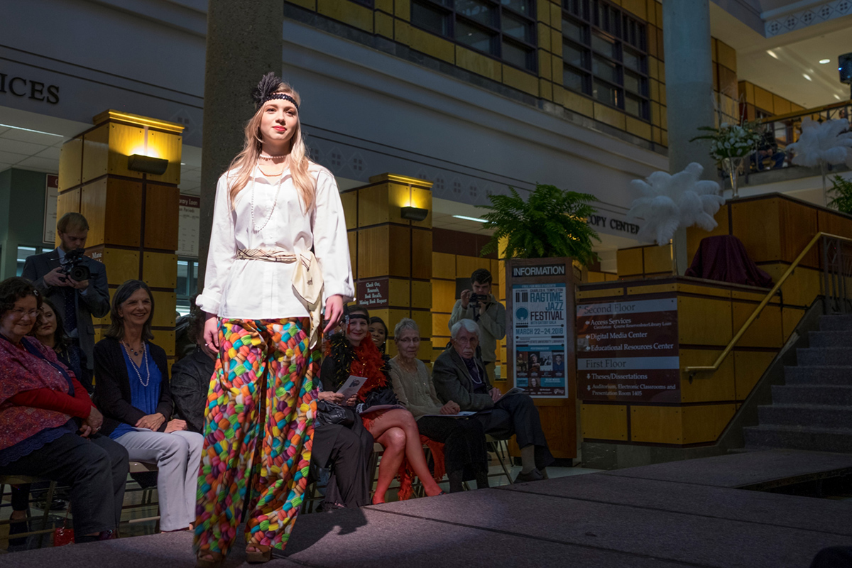 Student wearing 1920s fashion on runway in Mitchell Memorial Library