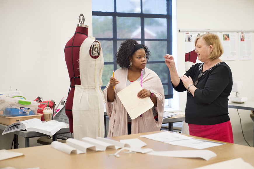 During fashion design and merchandising class, visiting professor Catherine Black gives student Fleshia Gillon advice on draping her clothing design.
