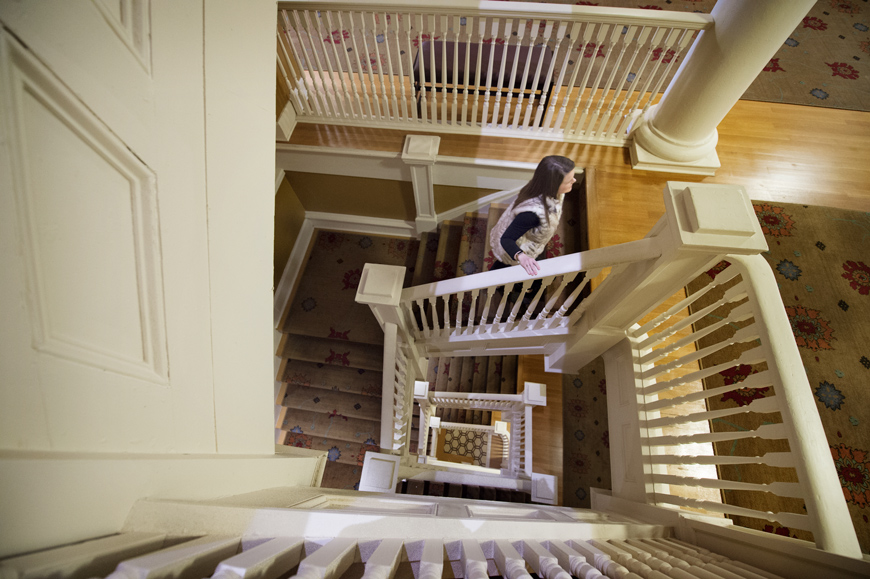 View looking down into Lee Hall stairwell from third floor, with Adminstrative Assistant Carmen Kelly ascending stairs