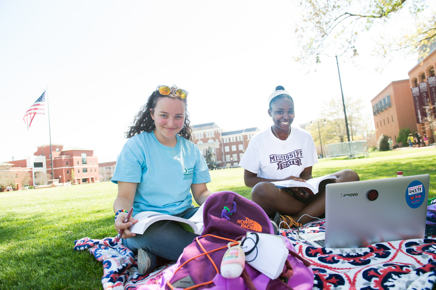 Friends Juliana Martinez and Quaneisha Clayton study on a Drill Field blanket on a a beautiful Spring Day.