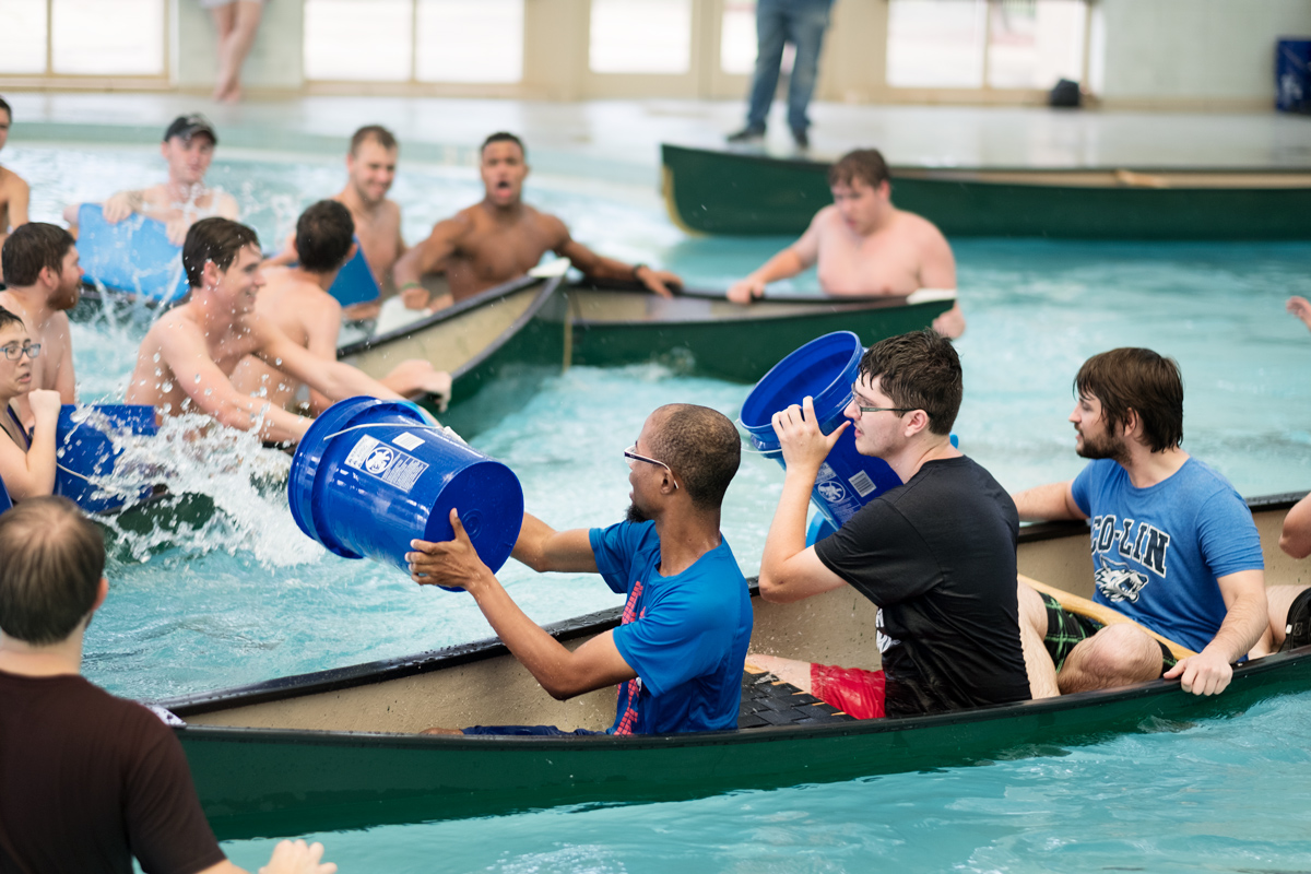 Canoes full of students throw buckets full of water at eachother in an attempt to sink each other&amp;#039;s boats.