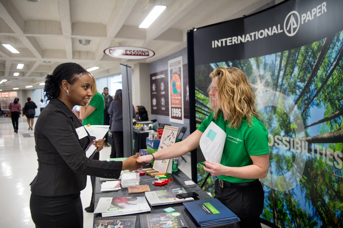 Student Annie Taylor shakes hands with International Paper representative during Career Days.