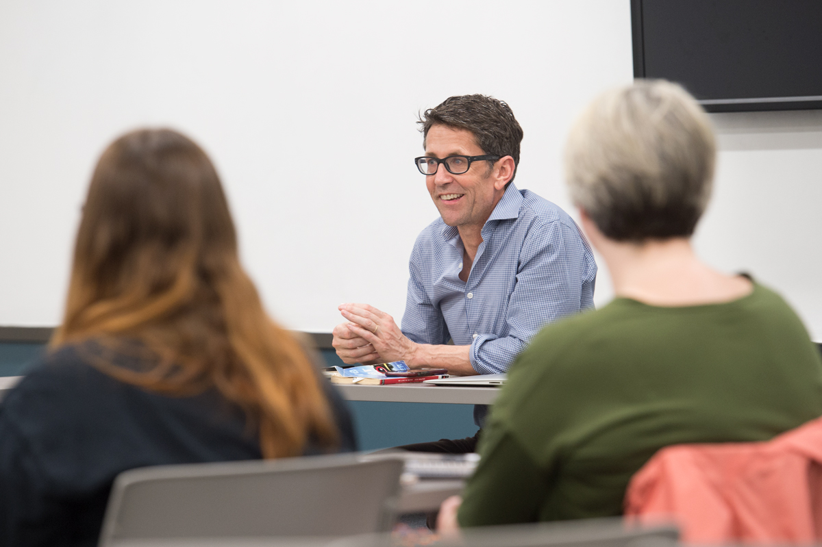 Writer-in-Residence Jess Walker speaks to students in small room fiction class.