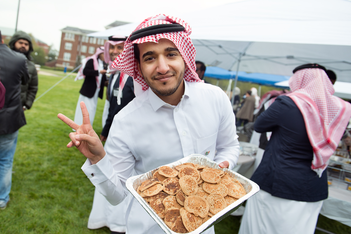 Student Mohammed Almtiri offers pancakes from the Saudi Arabian Student Association booth.