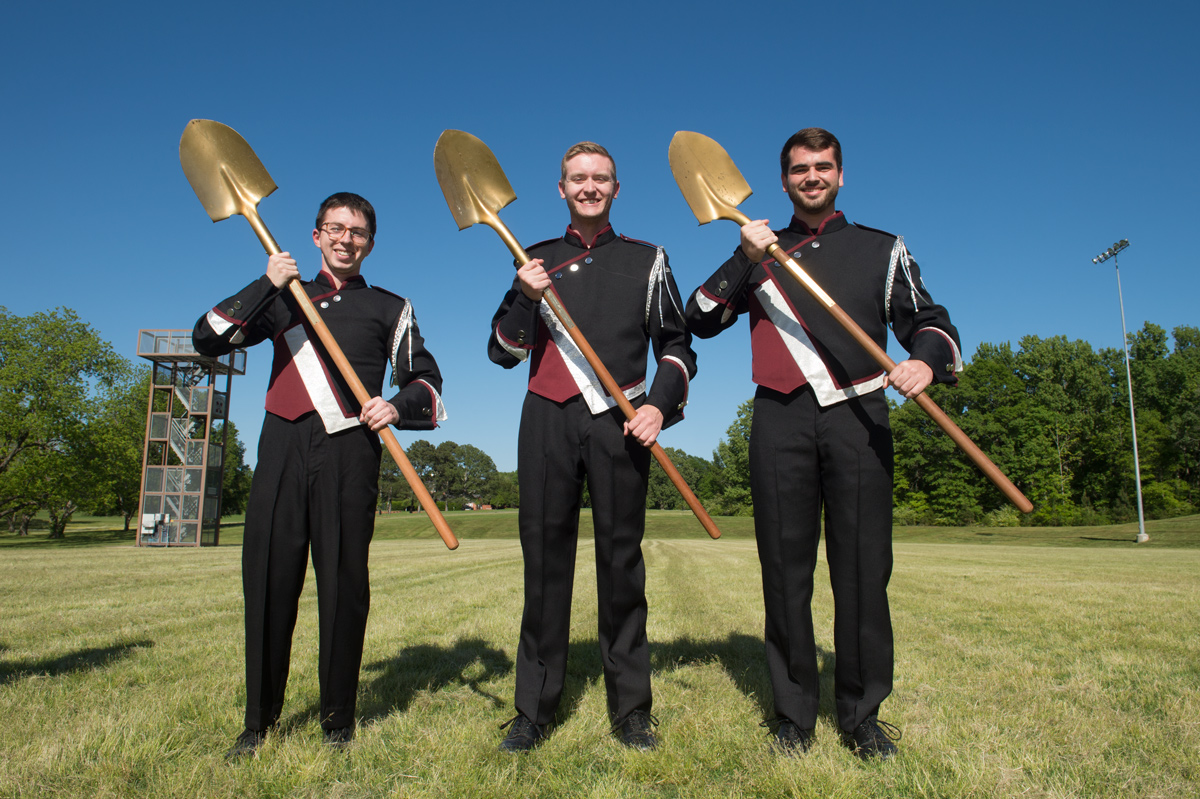 For the groundbreaking ceremony at the band practice field, the three drum majors hold golden shovels instead of their batons.