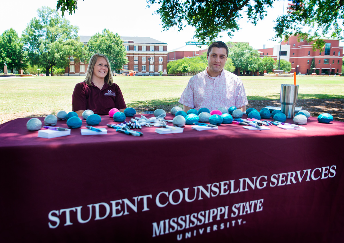 Student Counseling Services booth covered in stress balls set up on the Drill Field with two employees seated behind