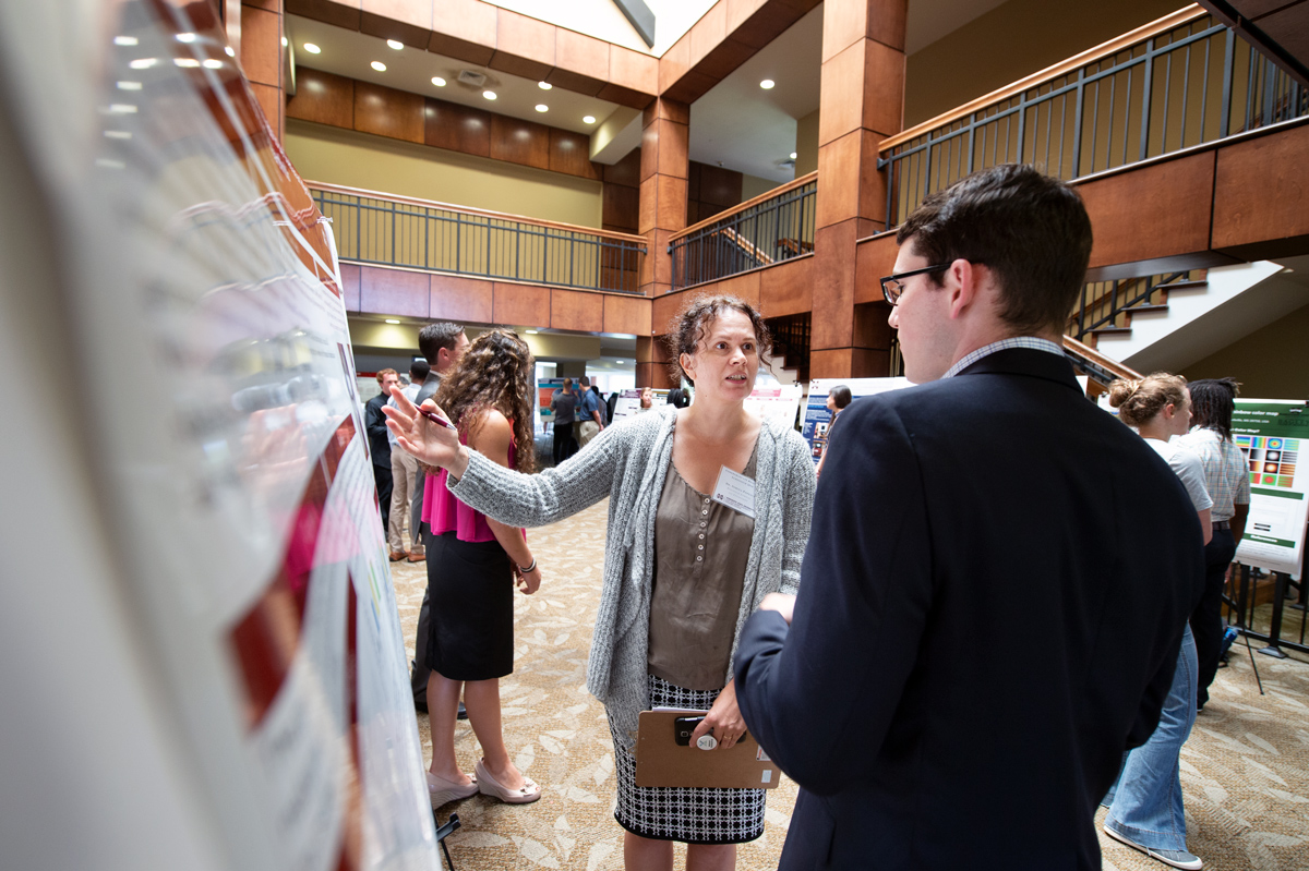 Assistant Professor Sorina Popescu asks student Paulino Jarquin about his research in Griffis Hall atrium.