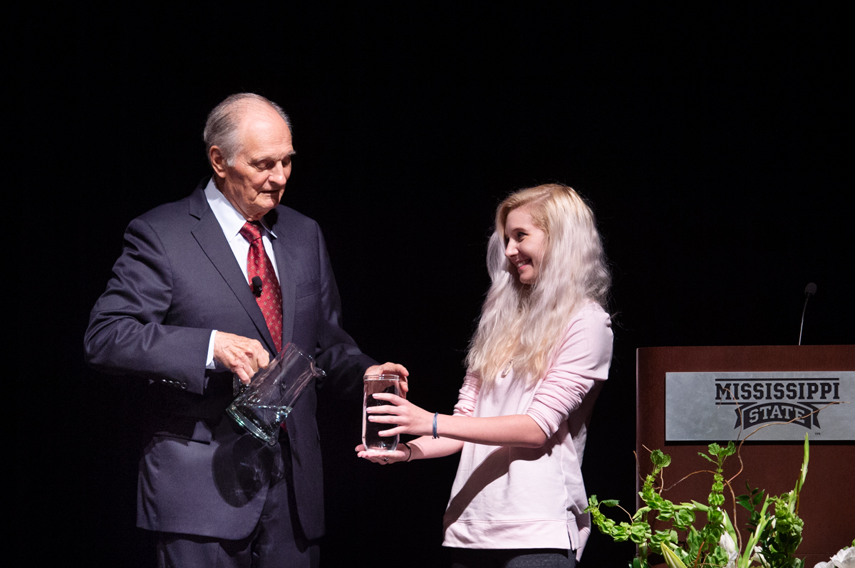 Alan Alda works with audience member Alex VBaldwin to demonstrate compelling story-telling with a glass of water.