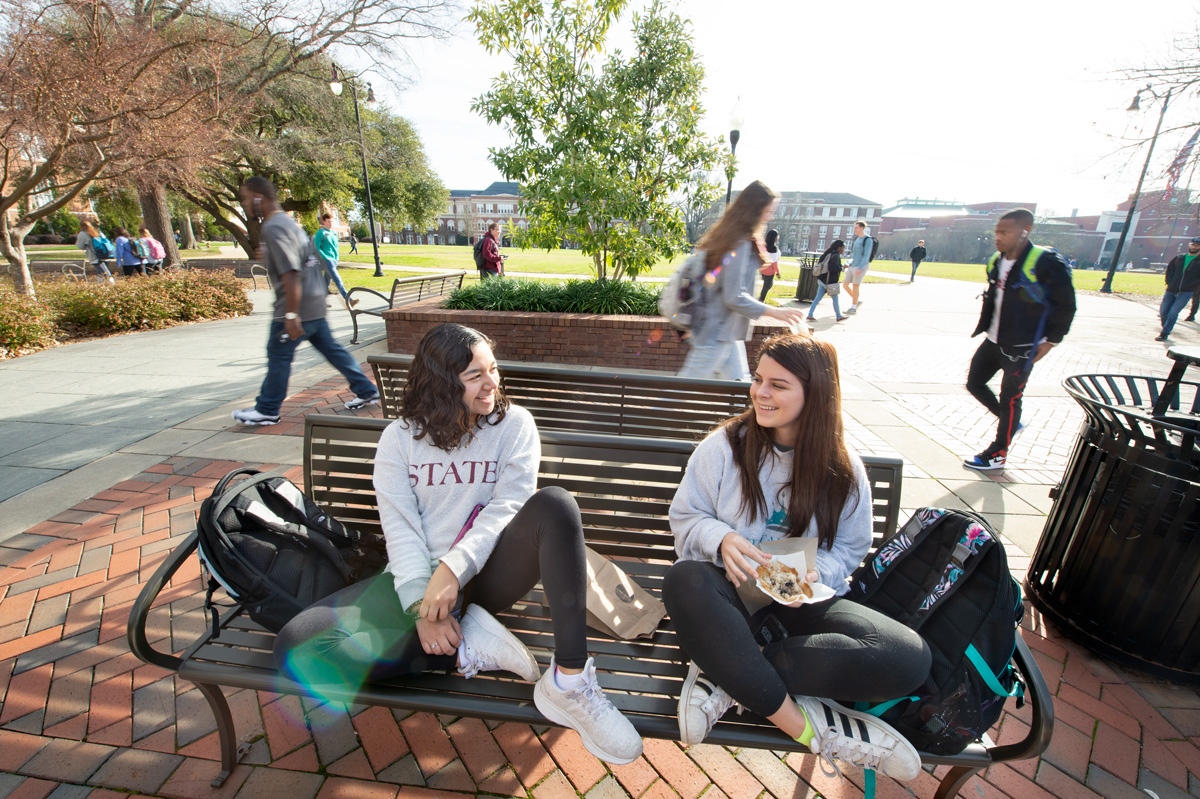 Students Paola Hernandez and Mary Frances Sessions share a laugh while hanging out on a Union Plaza bench. 