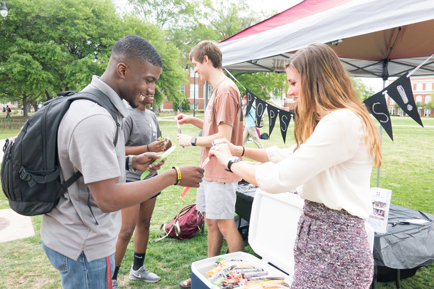 Female MSU Student Association president handing out popsicles to students