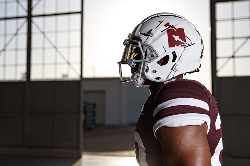 A football players models the Flying-M uniform inside the hangar of the Advanced Composites Institute