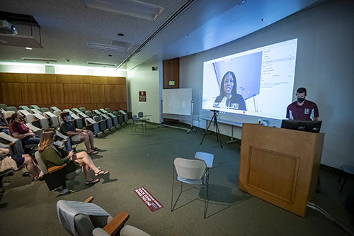 MSU College of Forest Resources instructor Chris Ayers is pictured at a podium, and U.S. Fish and Wildlife Service Director Aurelia Skipwith is pictured speaking to MSU students via Webex.