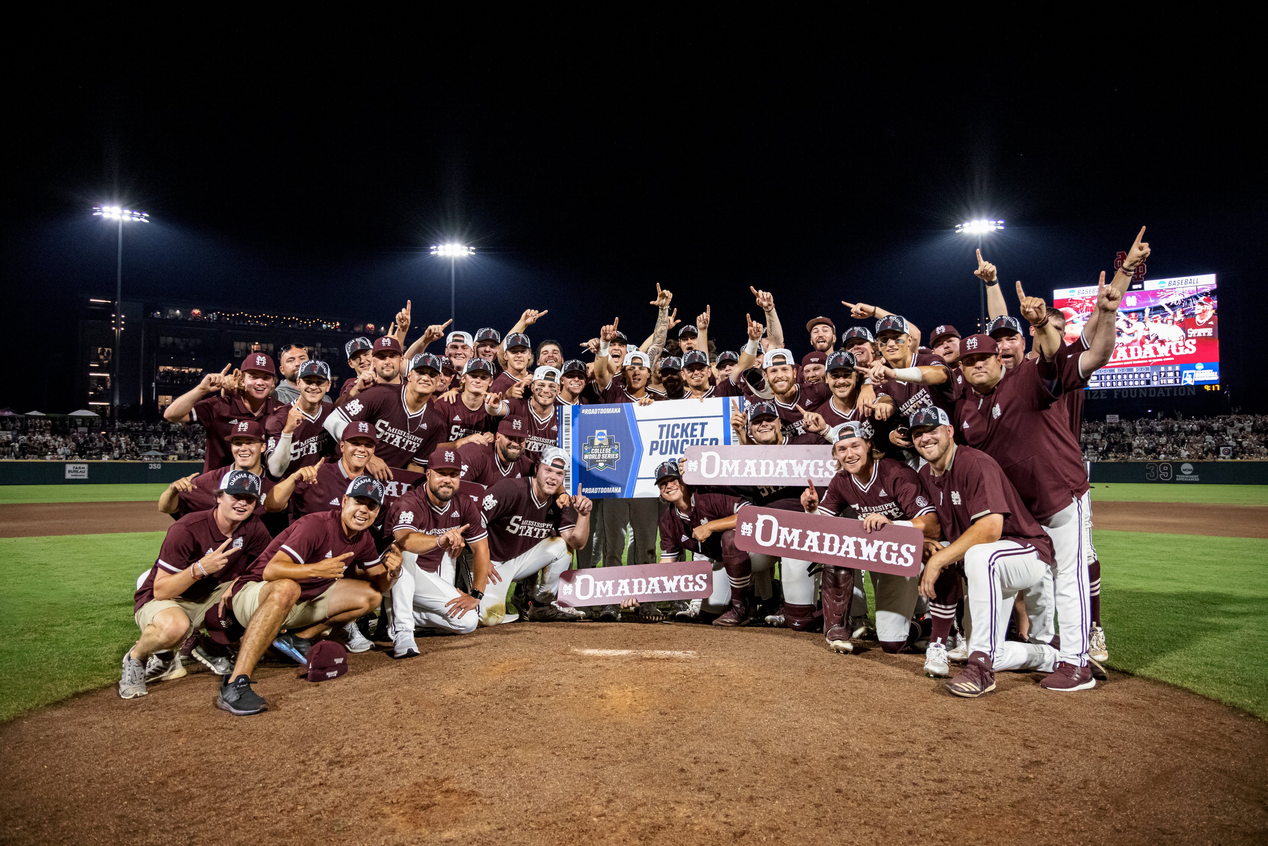 Group photo of MSU Diamond Dawgs and coaches after the team earned its 12th trip to the College World Series with a victory over Notre Dame at Dudy Noble Field.