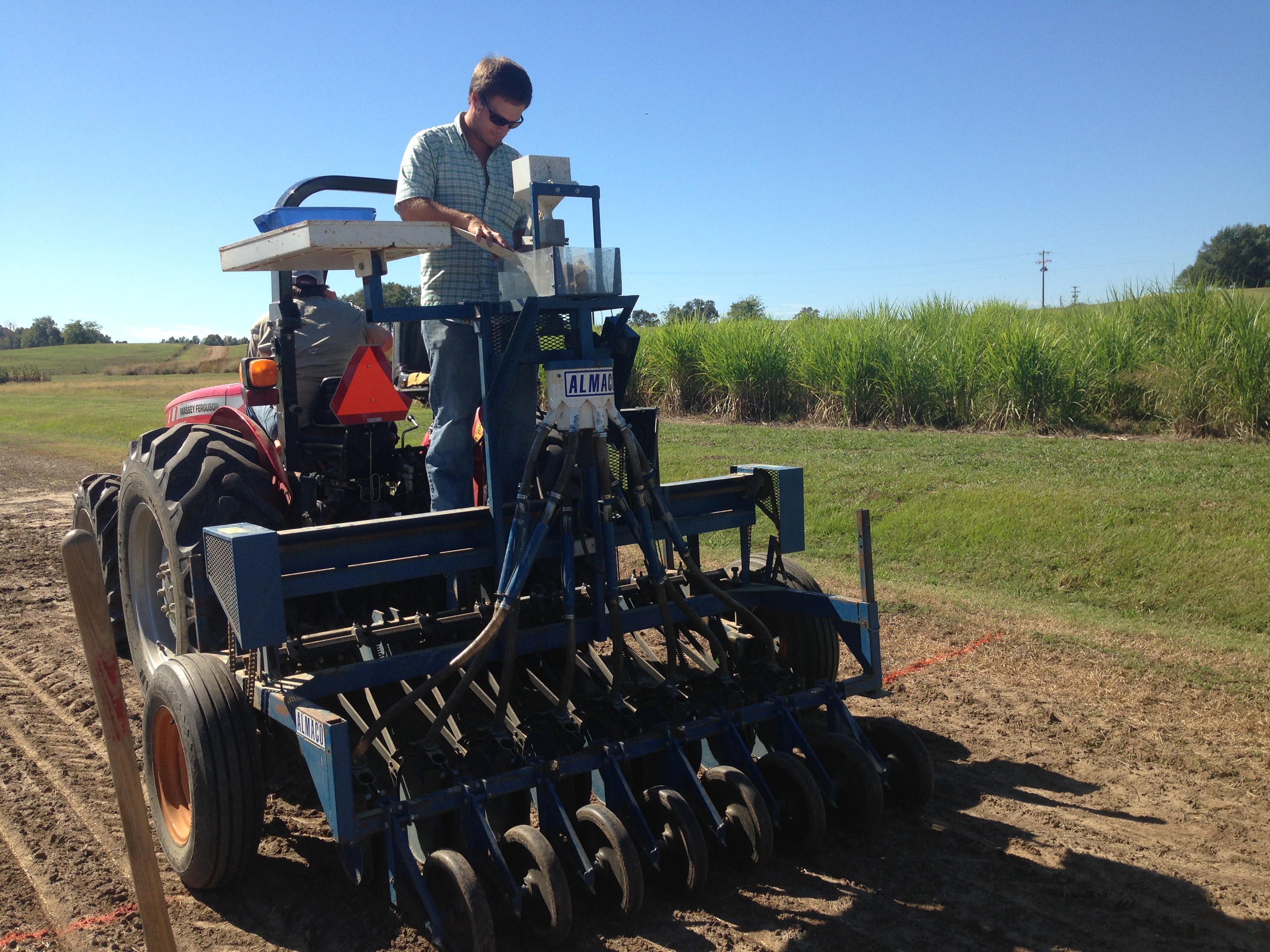 Richwine operates an Almaco 8-row plot drill being pulled behind a tractor to plant each plot.