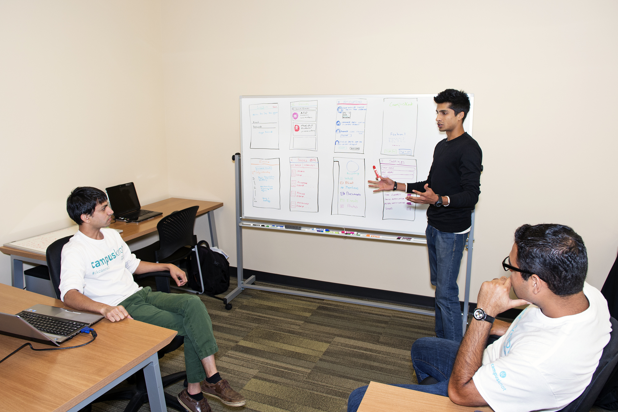 Rahul Gopal (standing), Hitem Patel (seated left) and Perceus Mody (seated right), discuss details for evolving their free social media site, CampusKnot, for focus-group testing this fall. A Gulf Coast businessman recently invested $100,000 with the company, which has set up shop in the business incubator at the Thad Cochran Research, Technology and Economic Development Park. 