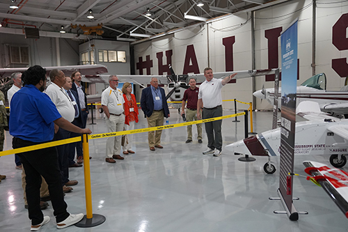 Raspet employees give a tour surrounded by UAS and planes.