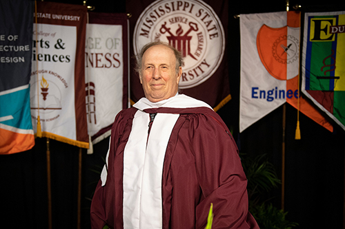 Alan I. Marcus wearing regalia on an MSU commencement stage