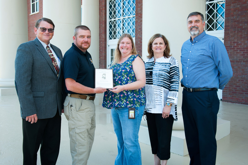 Alicia Musselwhite (center) is the Building Officials Association of Mississippi’s selection for 2017 Fire Code Official of the Year. Since 2009, she has led MSU’s fire and life safety programs. B.J. Malley, deputy state fire marshal, (second from left) presented the award. With them are (from left) Michael S. Parsons, MSU environmental and health safety director; Amy Tuck, MSU vice president for campus services; and Glynn Babb, emergency and safety officer for the Board of Trustees, State Institutions of Higher Learning. (Photo by Russ Houston)