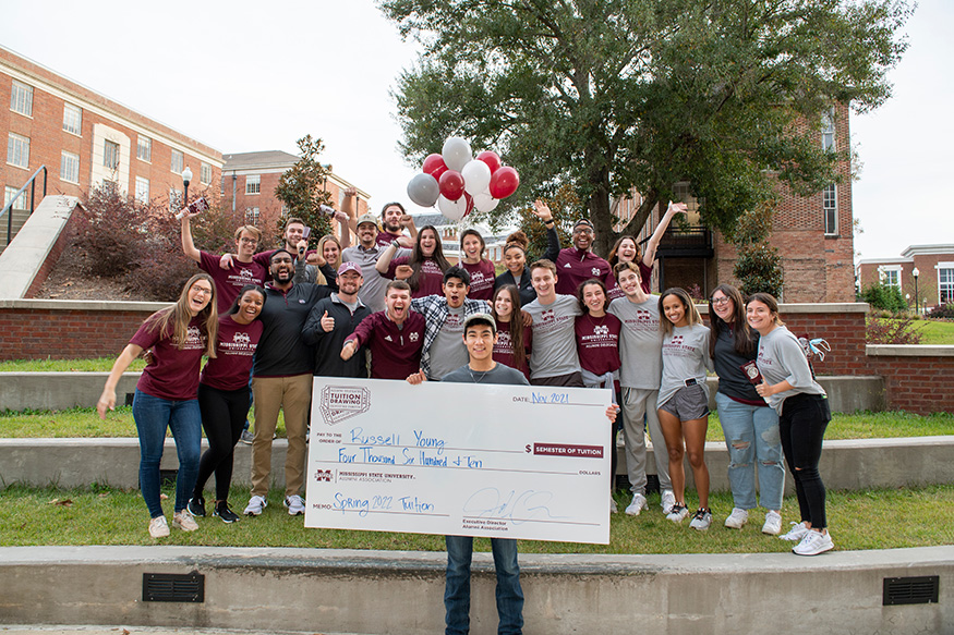 Tuition drawing winner Russell S. Young of Pensacola, Florida, holds a large check while standing with members of the MSU Alumni Delegates organization.