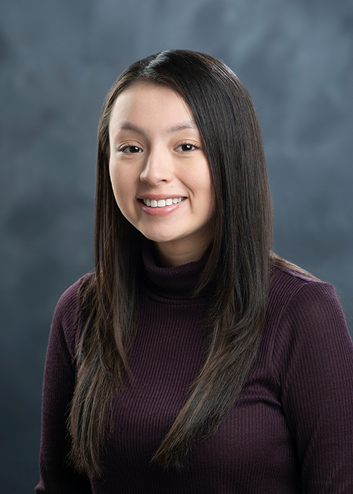 Close-up portrait of Sofia Alvarez wearing a mauve sweater