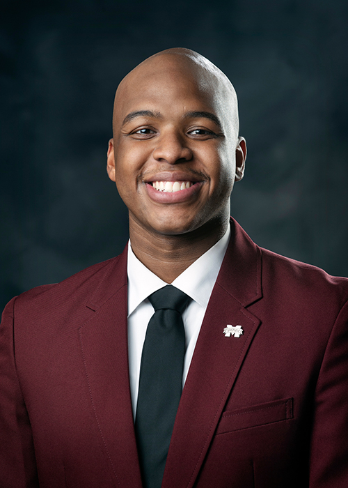 Studio portrait of MSU senior Andrade Donovan wearing a maroon blazer and M-State lapel pin