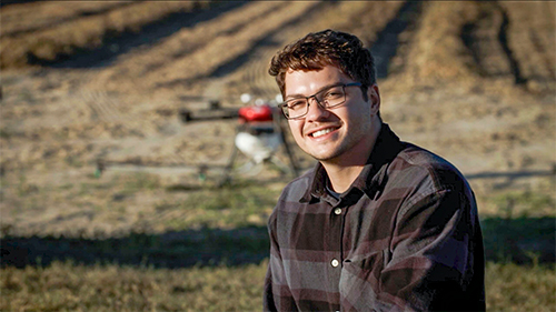 Antonio Augusto Tavares in a field with a UAV in the background. 