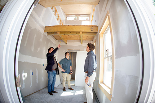 George Martin, left, visiting associate professor in Mississippi State’s Building Construction Science program, discusses the wooden tiny house construction project with students Evan Hodges and Collin Manuel during a recent presentation on the Starkville campus. Martin was among faculty and construction professionals who toured the house and provided feedback to the students on their work. (Photo by Megan Bean)