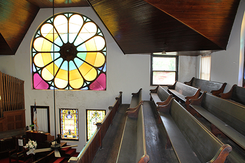 Pews pictured below a stained glass window at Bethel AME Church in Vicksburg