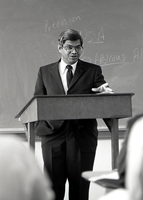 Former MSU Political Science Professor Dr. Krishnaprasad G. (Krish) Bhansali pictured teaching at a podium.