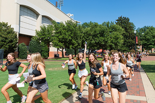 Students run into Davis Wade Stadium on Panhellenic bid day