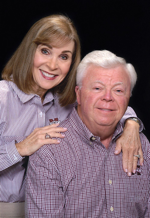 MariAnna and Fred Brown studio portrait, wearing MSU shirts in front of black background