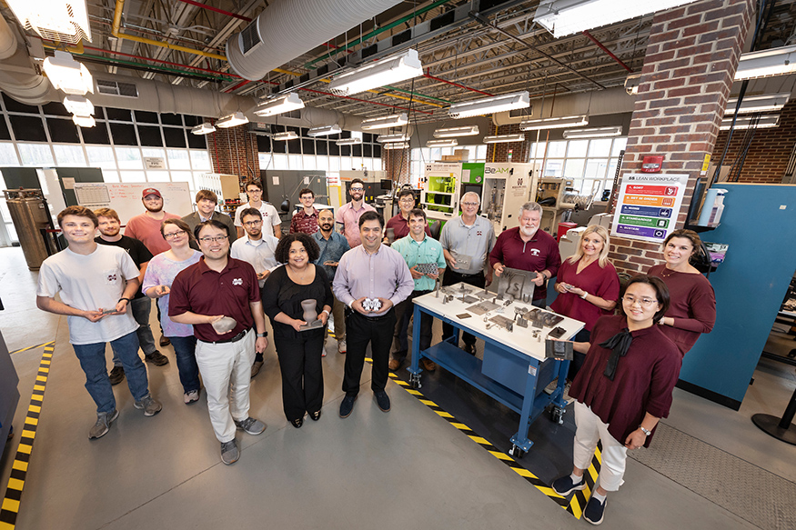 MSU researchers pose for a picture in CAVS' additive manufacturing lab
