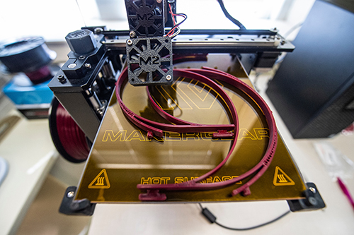 A 3D printer makes face shield parts