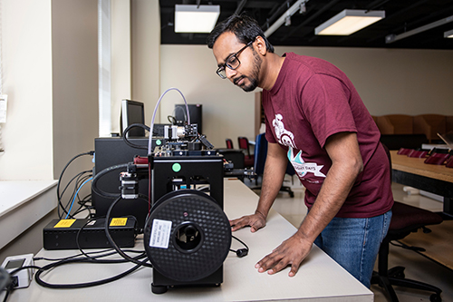 A graduate student makes facie shields in McCain Hall