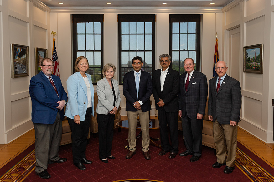 A group of leaders pose for a photo in MSU's Office of the President