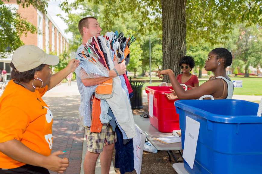 From left, Mississippi State senior Jessica Y.N. Arceneaux and juniors Chastiti M. Johnson and Ashley M. Hollins accept clothes from senior Hayden J. Warner during a Tuesday [Aug. 18] donation drive on the university’s Drill Field. Members of the Nu Beta Chapter of Delta Sigma Theta Sorority are among campus and community organizations that are collecting a variety of items that will benefit thousands affected by recent widespread flooding in south Louisiana and parts of Mississippi. (Photo by Robert Lewis)