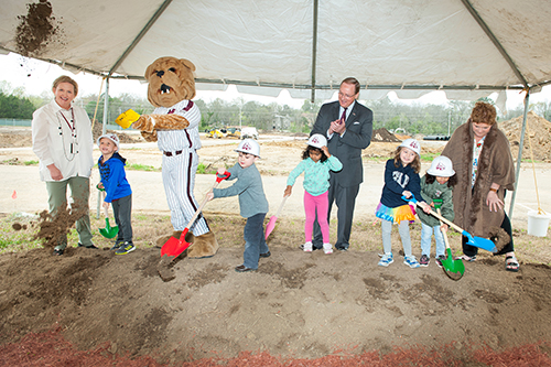 A group of children from Mississippi State’s Child Development and Family Studies Center (CDFSC) celebrate the ground breaking of the College View development, which includes a 7,000-square-foot daycare center. Accompanying the kids are, from left, CDFSC Director Melissa Tenhet, Bully, MSU President Mark E. Keenum and CDFSC Director and Teacher Lucy Bryant. (Photo by Russ Houston)