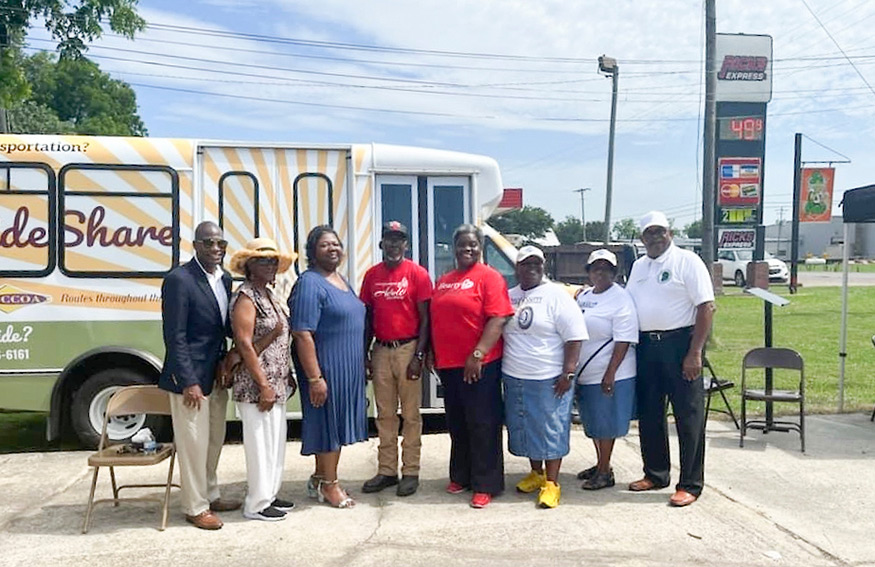 Those supporting the Health Destination Access program stand in front of a Rideshare bus