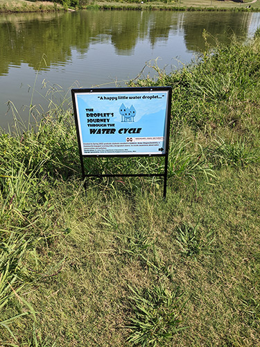 An educational sign near a small body of water