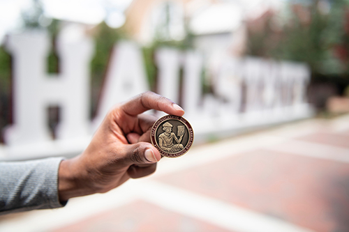 A commemorative Convocation coin is held for an up-close shot