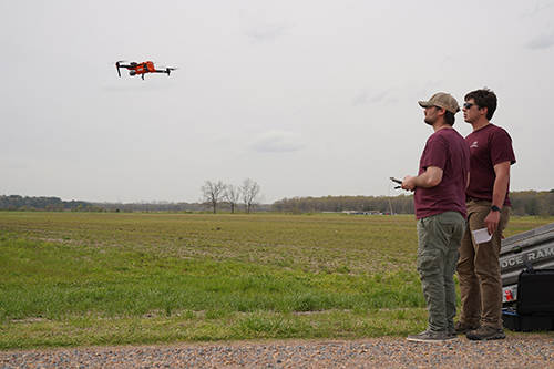 Taylor Eskridge (left) and Nolan Parker, flight operations technicians at the MSU’s Raspet Flight Research Laboratory, pilot a small UAS at the university’s R.R. Foil Plant Science Research Center.