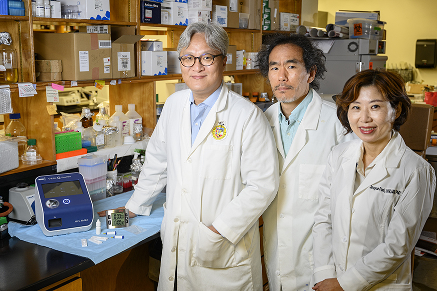 Keon Seok Seo, Joo Youn Park and Nogi Park stand beside their COVID-19 antibody rapid test invention.