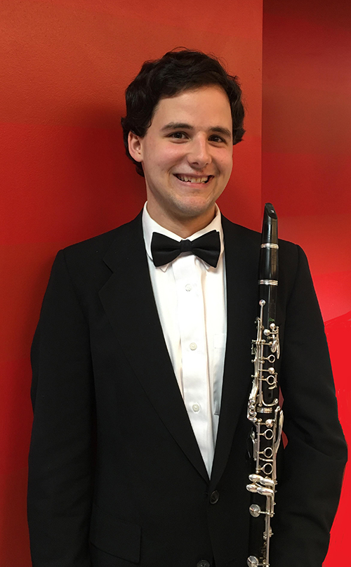 Docher Award recipient Daniel Rorabaugh smiles while holding a clarinet.