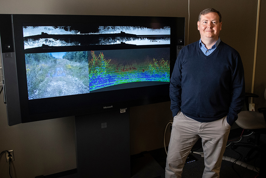 Daniel Carruth, pictured in front of a screen with virtual environments