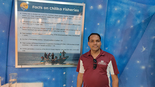 Padmanaya Dash, pictured in front of a sign about Chilika Lake